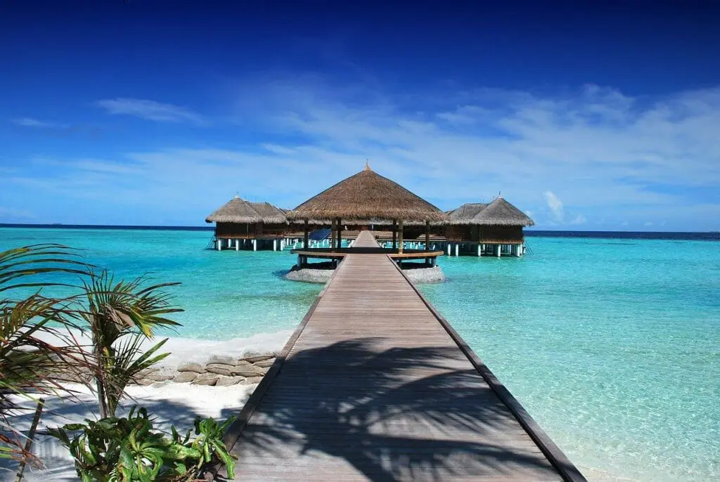 mejores destinos para viajar en diciembre maldivas pasarela de madera cabañas