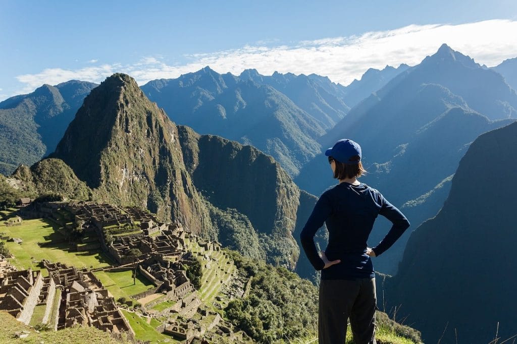 mujer frente a las ruinas de Machu Picchu en día soleado