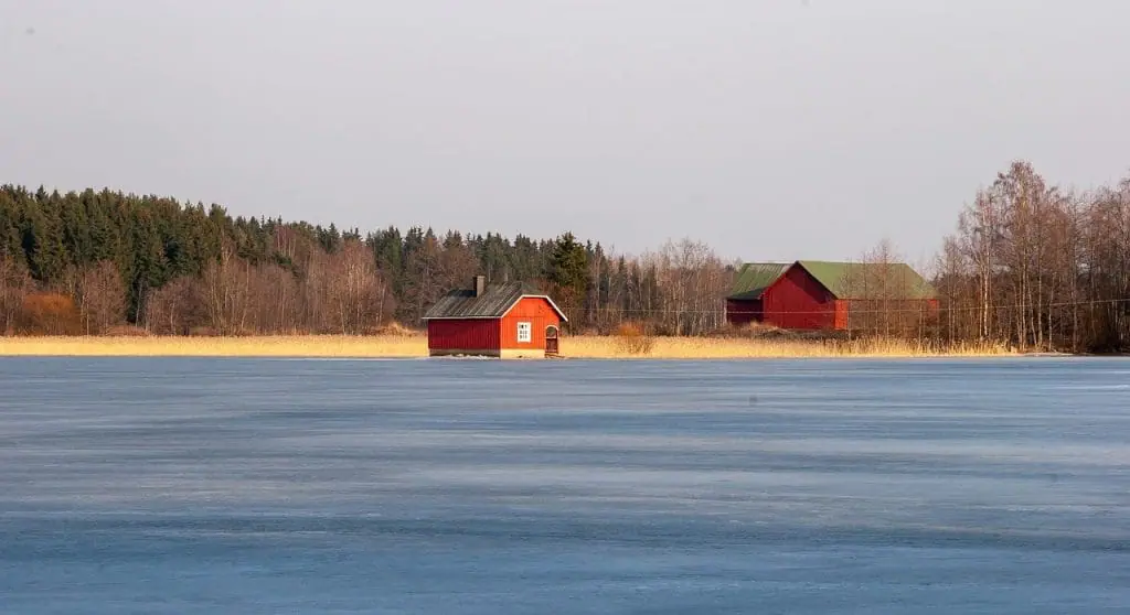 Cabañas de saunas finlandesas junto a lago gélido