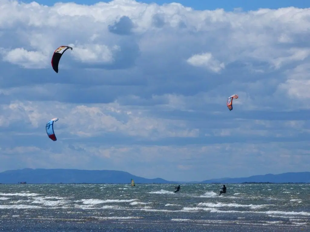 Varias personas practicando kitesurf en el mar