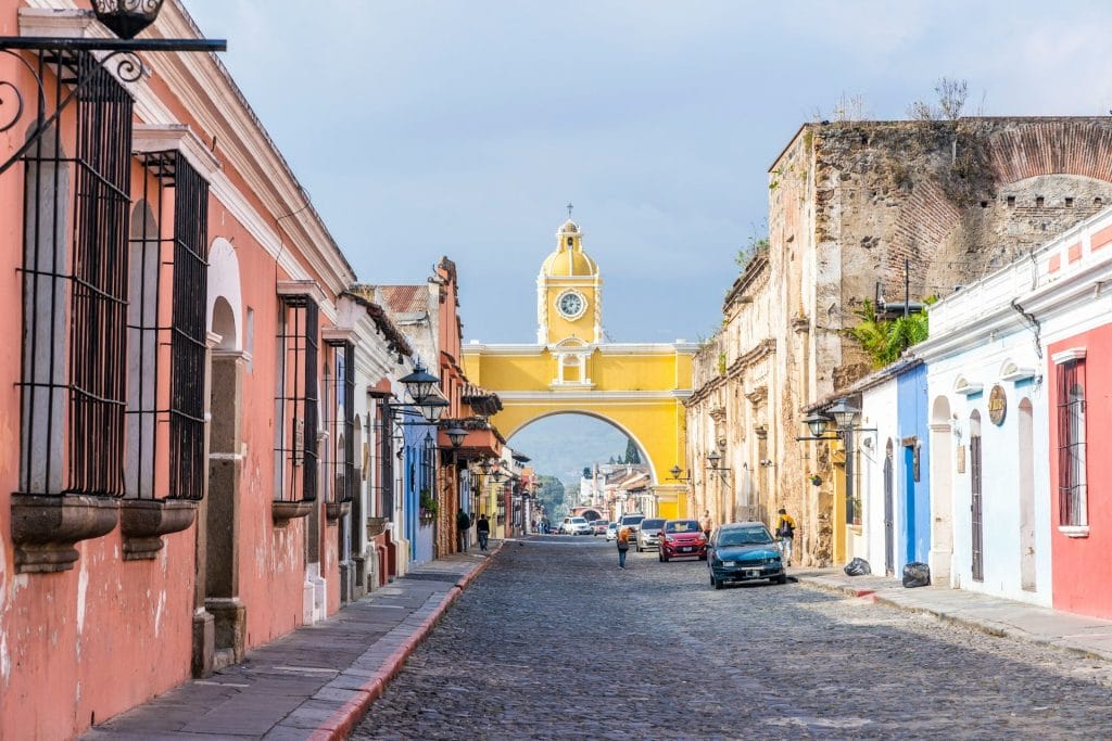 casas coloridas asoman a calle adoquinada y arco